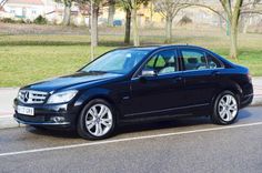 a black car is parked on the side of the road