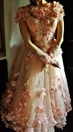 a mannequin dressed in a pink dress with flowers on it's chest