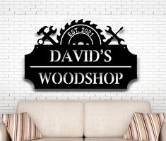 a sign that says david's woodshop hanging on the wall next to a couch