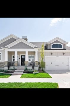 a large white house with two garages on the front and one car parked in front