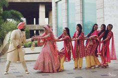 a bride and groom dancing with their bridal party in front of the hotel entrance