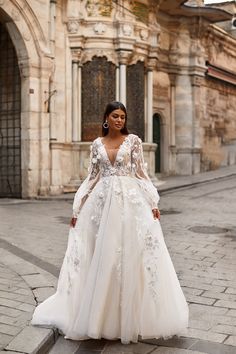 a woman in a wedding dress standing on the street