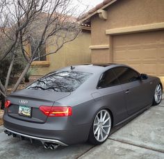 a grey car parked in front of a house