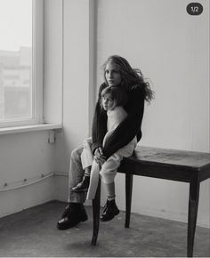 black and white photograph of two children sitting on a bench in front of a window