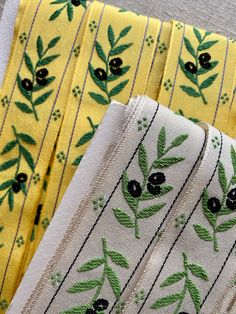 four pieces of cloth with olives and leaves on them, all in different colors