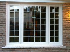 a white window sitting on the side of a brick building