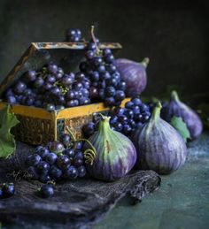 an assortment of grapes and figs on a cloth