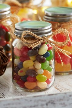 several jars filled with candy sitting on top of a wooden table next to other candies