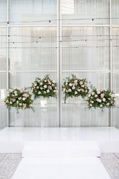 two vases filled with flowers on top of a white table