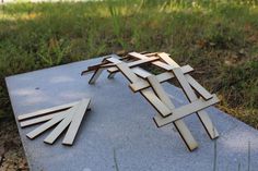 a sculpture made out of wood sitting on top of a cement slab