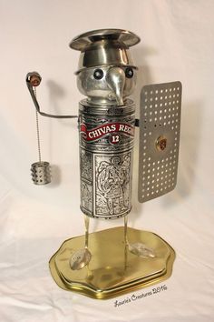 a robot made out of a wine bottle on a gold plated stand with a corkscrew attached to it