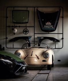 two sports cars are parked next to each other in front of a wall mounted clock