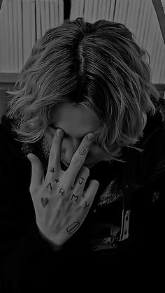 black and white photograph of a woman covering her face with both hands while sitting in a car