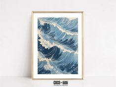 an ocean wave is framed in a gold frame on a white wall with the words coco - cola written below it