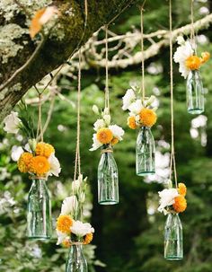 hanging mason jars filled with white and yellow flowers are the perfect way to add color to an outdoor ceremony