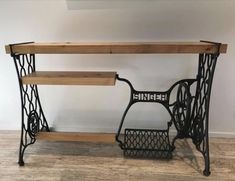 an old sewing machine sits on top of a wooden shelf next to a metal basket