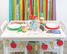 a party table set up with cupcakes, plates and napkins