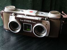 an old camera sitting on top of a wooden table