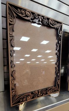 an old fashioned mirror is sitting on a shelf in a store or office building with no one around it