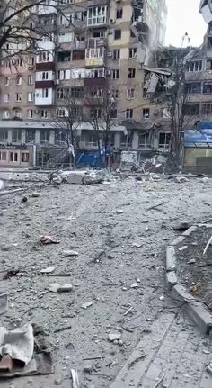 an abandoned building in the middle of a city with broken windows and debris on the ground