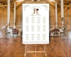 a wedding seating chart is displayed on an easel in a large room with wooden floors