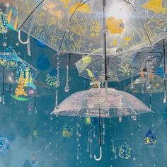 there are many umbrellas hanging from the ceiling in the sky with raindrops on them