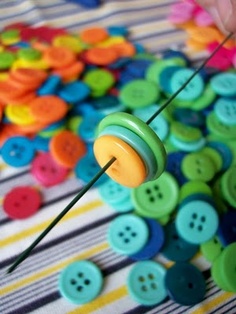 a person is sewing buttons on a striped tablecloth with colorful pins in the background