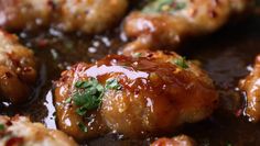 closeup of chicken wings with sauce and parsley in a skillet, ready to be eaten