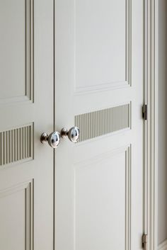 two white doors with chrome handles in a room