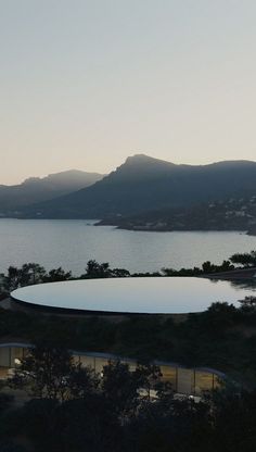 an aerial view of a large body of water with mountains in the background at dusk