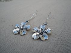 "These are unique and beautiful cherry blossom flower earrings. They are happy and fun. The charms measure about 5/8\" across as well as up and down. The dangle and dance from 1\" long kidney style earwires. Made from allergy free plated silver. The over all drop of the earrings is about 1 5/8\" long. These are perfect for everyday, year round wear and would also make a very nice gift. Tiger Flower Jewelry - Inspired by Nature" Blossom Flower Charm Earrings For Spring, Blossom Colored Flower Charm Earrings For Spring, Blossom Color Flower Charm Earrings For Spring, Blossom Color Earrings With Flower Charm For Spring, Silver Flower Earrings For Spring Gift, Spring Flower Dangle Earrings Gift, Whimsical Earrings For Spring Gift, Whimsical Spring Flower Earrings For Gift, Whimsical Spring Earrings For Gift