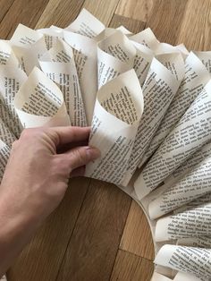 a person is making a wreath out of book pages