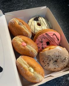 a box filled with lots of different flavored donuts