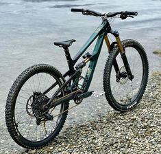 a mountain bike parked on top of a rocky beach