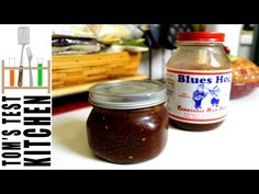 two jars of food sitting on top of a counter next to a knife and fork