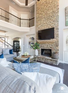 a living room filled with furniture and a flat screen tv mounted on the wall above a fireplace