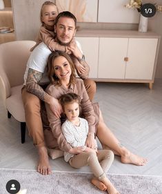 a family sitting on the floor in their living room