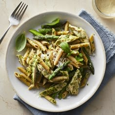 a white plate topped with pasta and asparagus