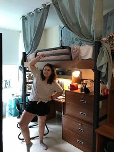 a woman standing in front of a bunk bed