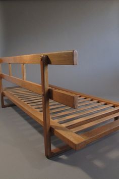 a wooden bed frame sitting on top of a gray floor