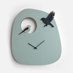 a clock with a face and two birds on it's face, in the shape of a bird