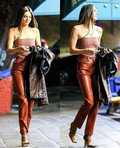 two women walking down the street in leather pants