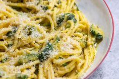 a plate of pasta with broccoli and parmesan cheese