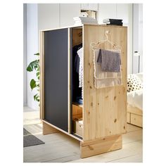 a wooden cabinet with clothes hanging on it