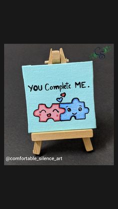 a small easel with a sign on it that says you complete me and three little elephants