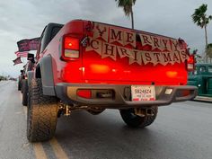 a red pick up truck parked on the side of the road with christmas decorations painted on it