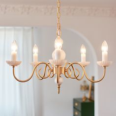 a chandelier hanging from a ceiling in a room with white walls and curtains