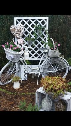 an old bicycle with baskets on the back is parked in front of a garden bench