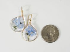 Forget me not Earrings, Resin Earrings, Pressed Flowers Earrings, GOLD Filled, Resin jewelry, Natural Jewelry, dainty Earrings Forget me not flowers are carefully pressed and put them into crystal resin. I added extra forget me not flowers on top of flowers with stems. The material of earwire is 14K GOLD FILLED. The eco-friendly resin (derived from tree sap) is crystal clear, allowing you to see many different types of rhinestones and metal parts. Size: tops; approximately 20×25mm, Gold color ch Flowers With Stems, Forget Me Not Flowers, Tree Sap, Flowers Earrings, Natural Jewelry, Crystal Resin, Earrings Resin, Jewelry Dainty, Resin Earrings