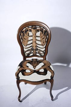 a skeleton sitting on top of a wooden chair next to a white wall and floor